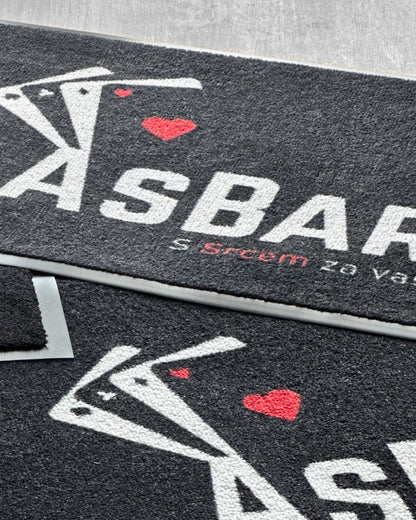 Predpražnik z logotipom pred vhodom v podjetje